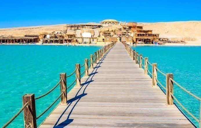 Wooden boardwalk leading to a luxury reclaimed waterfront community with turquoise waters, premium coastal developments, and modern infrastructure in Lagos.