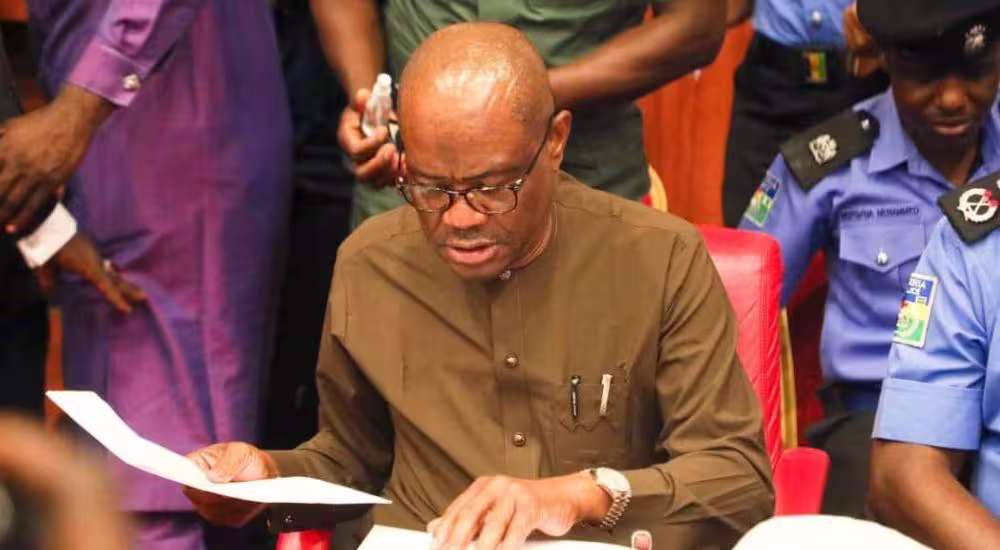 Wike signing/reviewing official documents.